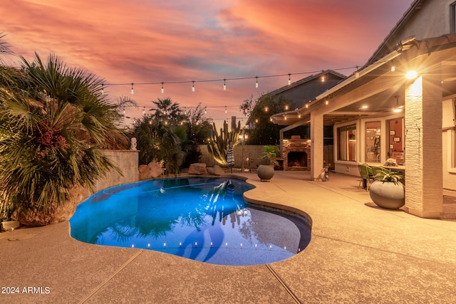 pool at dusk with a patio area