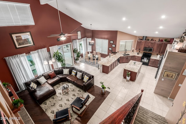 tiled living room featuring ceiling fan, sink, and high vaulted ceiling