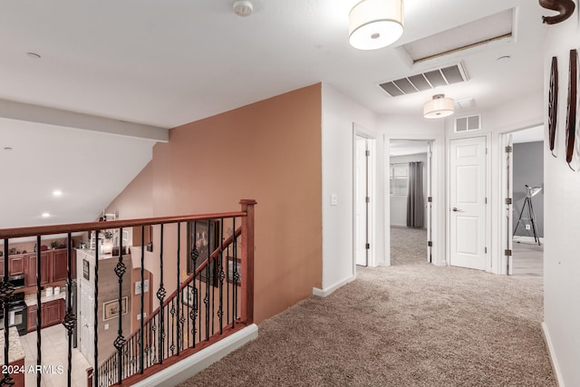 hallway featuring lofted ceiling and light colored carpet