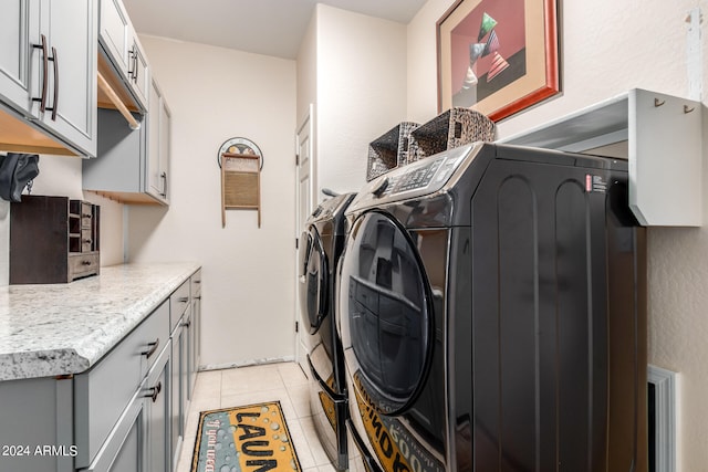 laundry room featuring cabinets, independent washer and dryer, and light tile patterned flooring