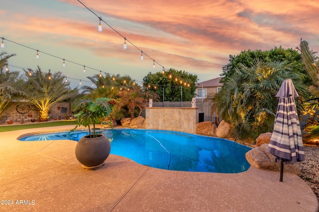 pool at dusk with a patio