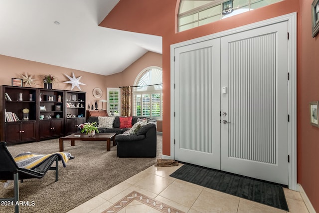 entryway with lofted ceiling and light tile patterned floors