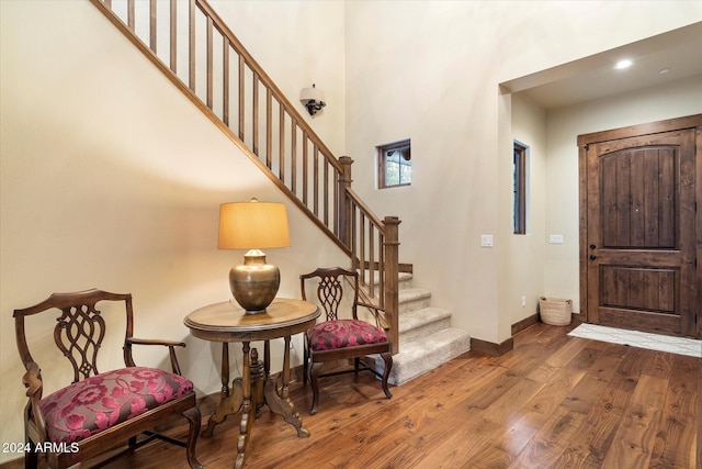 entrance foyer with hardwood / wood-style floors and a high ceiling