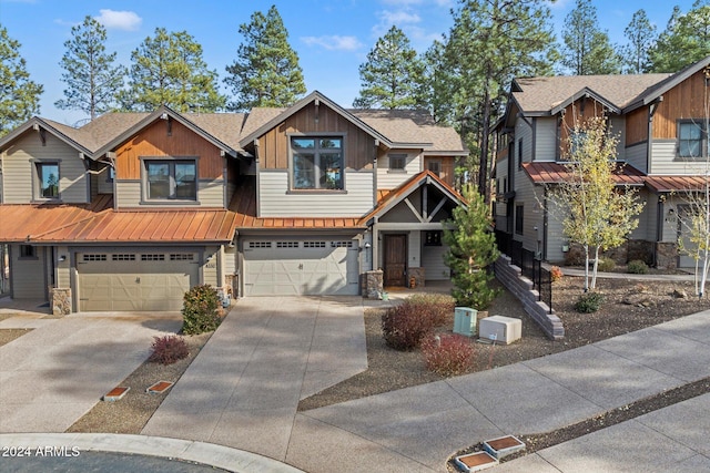 4320 W Arabian Trl, Flagstaff, AZ 86005 - view of front facade with stone siding, board and batten siding, driveway, and an attached garage