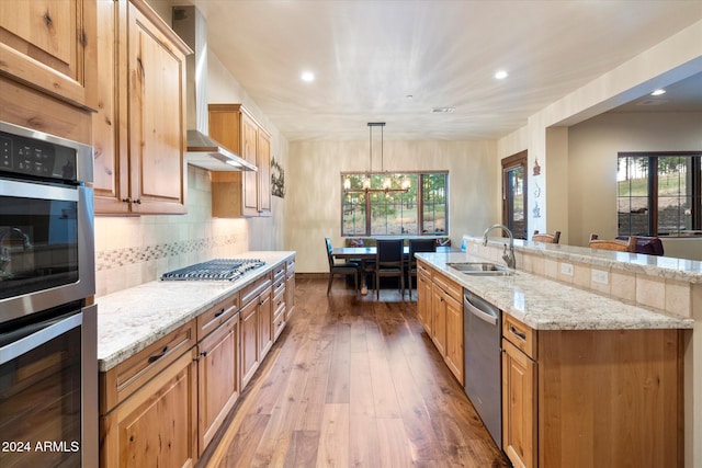 kitchen featuring pendant lighting, an inviting chandelier, sink, hardwood / wood-style flooring, and stainless steel appliances