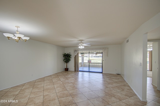 tiled spare room with ceiling fan with notable chandelier