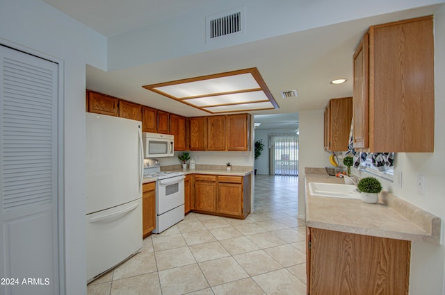 kitchen with white appliances, sink, and light tile patterned floors