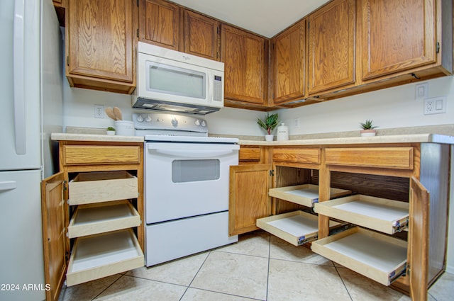 kitchen featuring light tile patterned floors and white appliances