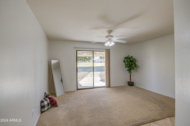 carpeted spare room featuring ceiling fan