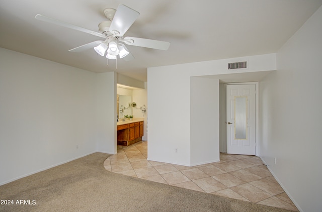 tiled empty room featuring ceiling fan