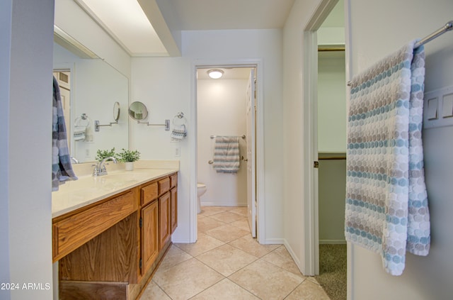 bathroom with tile patterned flooring, vanity, and toilet