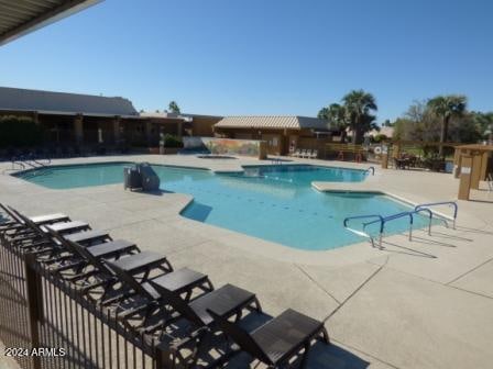 view of pool with a patio and a hot tub