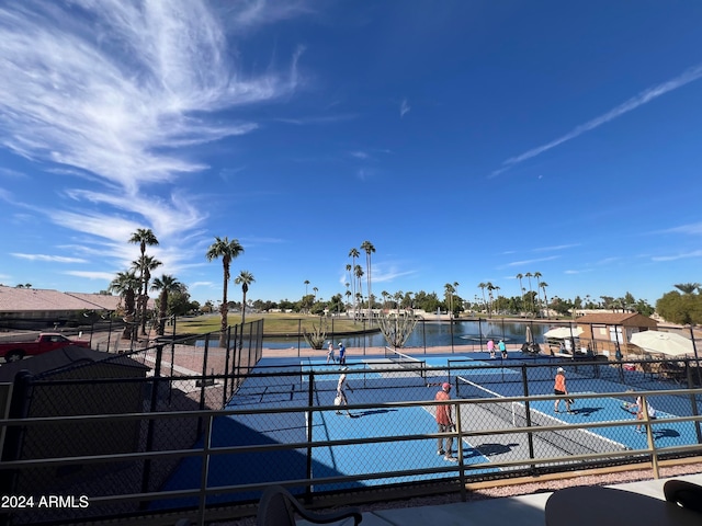 view of tennis court with a water view