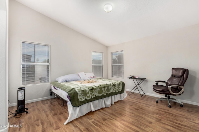 bedroom with hardwood / wood-style flooring, lofted ceiling, and multiple windows