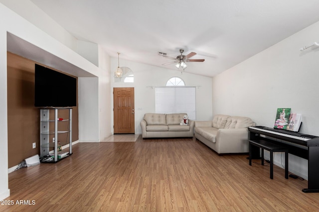 living room featuring wood-type flooring, lofted ceiling, and ceiling fan