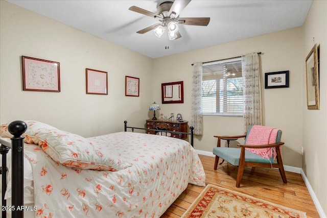 bedroom with light wood-style floors, baseboards, and a ceiling fan