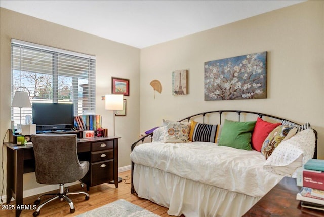 bedroom with light wood-style flooring and baseboards