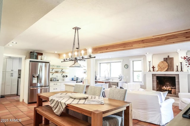 dining space with light tile patterned floors, a fireplace, beam ceiling, and recessed lighting