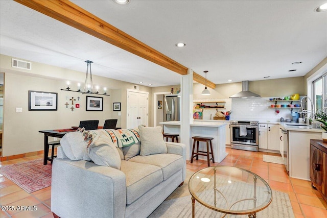 living room featuring light tile patterned floors, a notable chandelier, recessed lighting, visible vents, and beamed ceiling