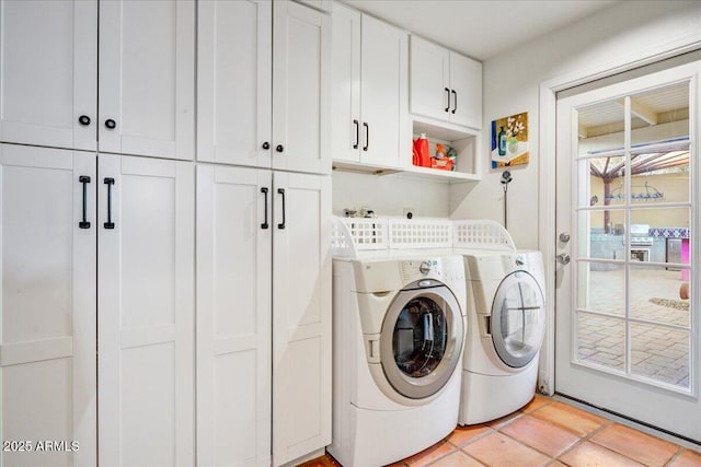 clothes washing area with light tile patterned floors, cabinet space, and separate washer and dryer