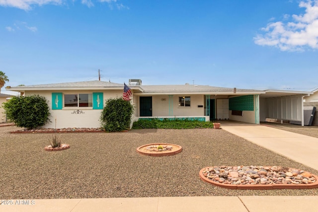 ranch-style house with an attached carport and concrete driveway