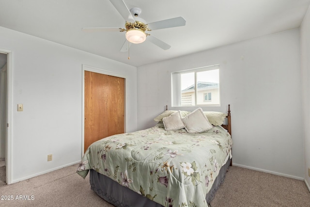 carpeted bedroom with a closet, baseboards, and a ceiling fan