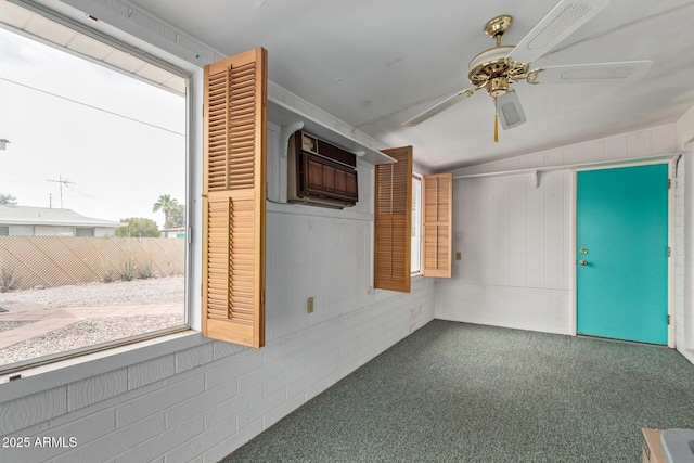 spare room with a ceiling fan, lofted ceiling, and carpet flooring