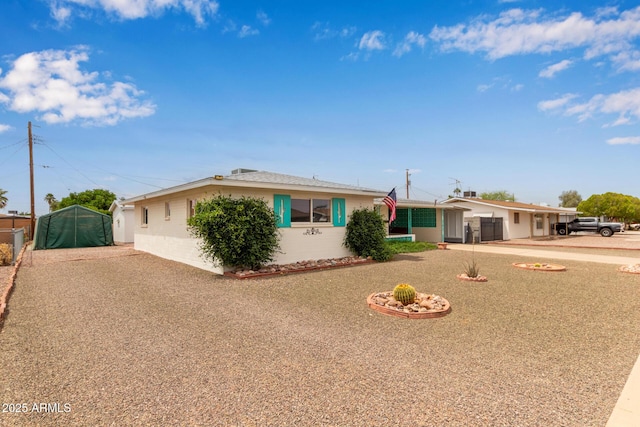 ranch-style house featuring driveway, stucco siding, and fence