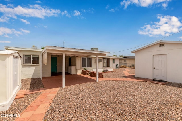 back of property featuring a patio area and an outdoor structure