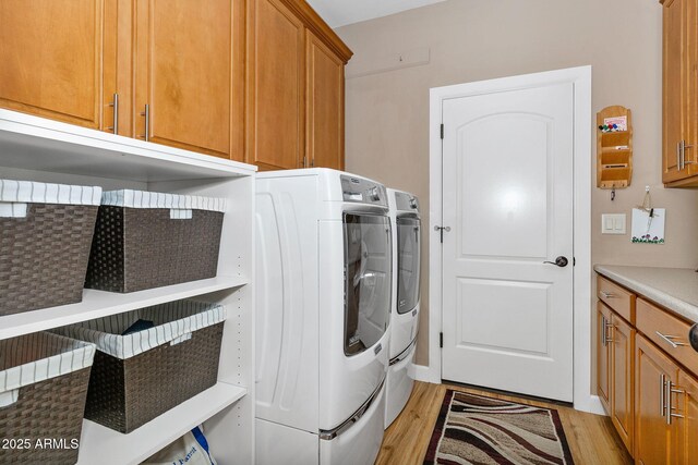 laundry room with separate washer and dryer, light wood finished floors, and cabinet space