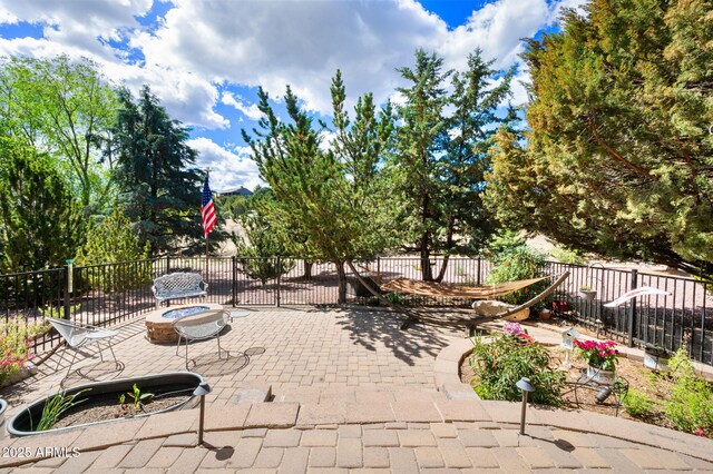 view of patio / terrace with an outdoor fire pit and fence