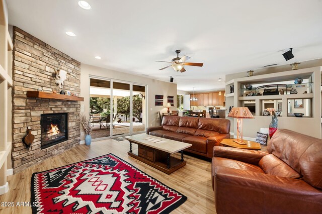 living area with light wood-style floors, recessed lighting, ceiling fan, and a fireplace