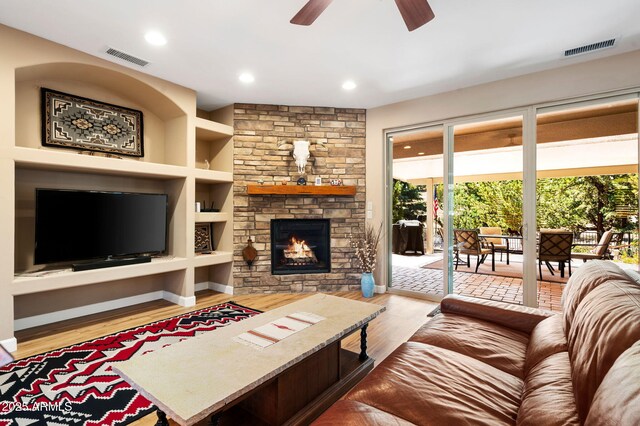 living room with a healthy amount of sunlight, ceiling fan, wood finished floors, and visible vents
