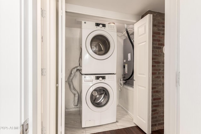 3633 N 3rd Ave Unit 2031, Phoenix, AZ 85013 - laundry area with stacked washer / drying machine, brick wall, and marble look tiles