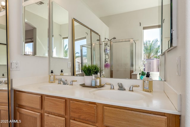 bathroom featuring double vanity, a shower stall, and a sink