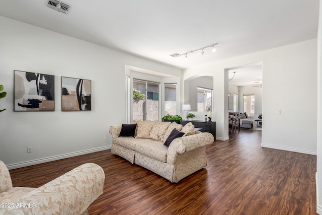 living area with visible vents, baseboards, and wood finished floors