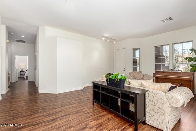 living room featuring wood finished floors, visible vents, and baseboards