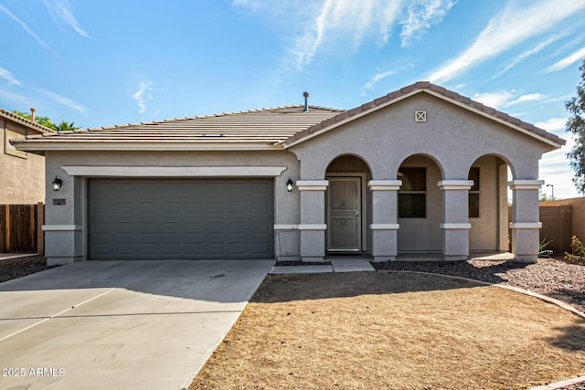 view of front of house featuring a garage, a tiled roof, concrete driveway, and stucco siding