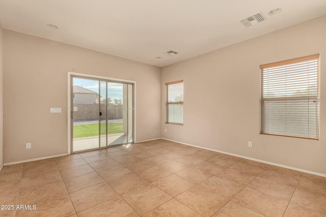 empty room with visible vents, baseboards, and light tile patterned floors