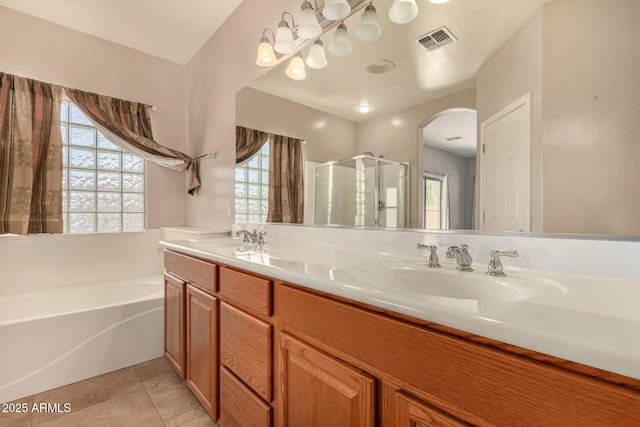 bathroom with a garden tub, a sink, visible vents, tile patterned floors, and double vanity