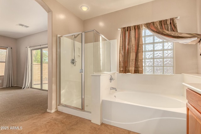 bathroom featuring a stall shower, visible vents, vanity, and a bath