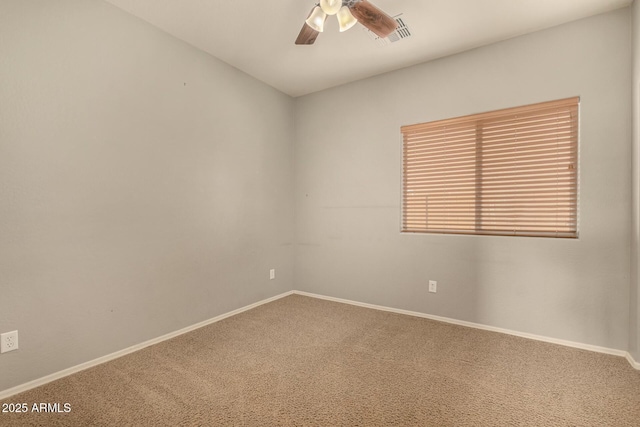 carpeted spare room featuring visible vents, a ceiling fan, and baseboards