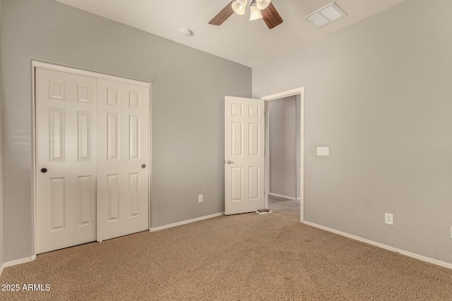 unfurnished bedroom featuring baseboards, visible vents, ceiling fan, carpet floors, and a closet