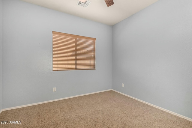 carpeted empty room with baseboards, visible vents, and a ceiling fan