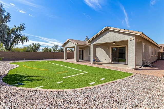 rear view of house featuring a patio area, a fenced backyard, a tile roof, and stucco siding