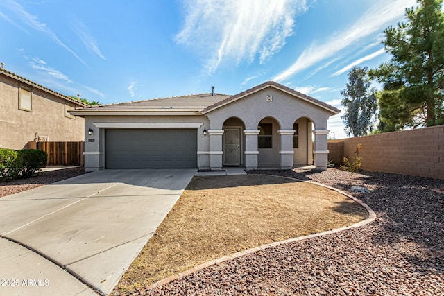 view of front facade with a garage, a tile roof, fence, concrete driveway, and stucco siding