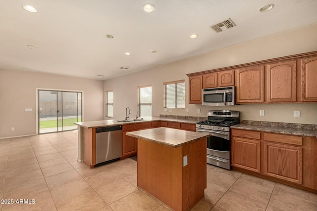 kitchen with stainless steel appliances, visible vents, a sink, and a kitchen island