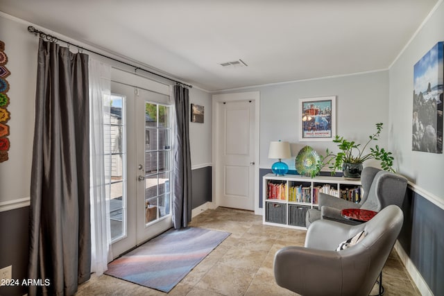 living area featuring french doors and crown molding