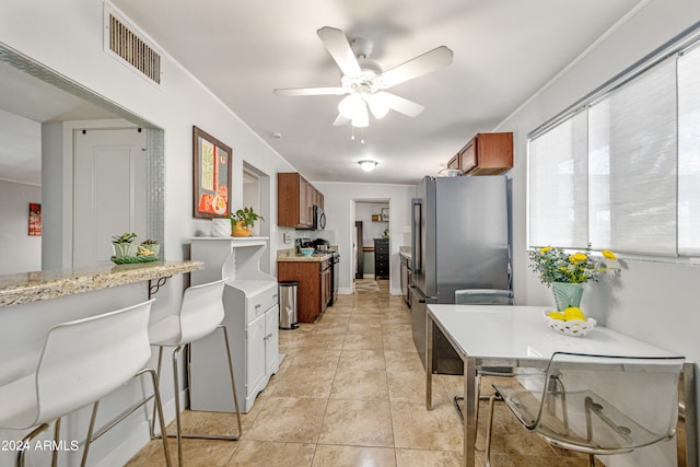 kitchen with ceiling fan, light tile patterned flooring, and appliances with stainless steel finishes