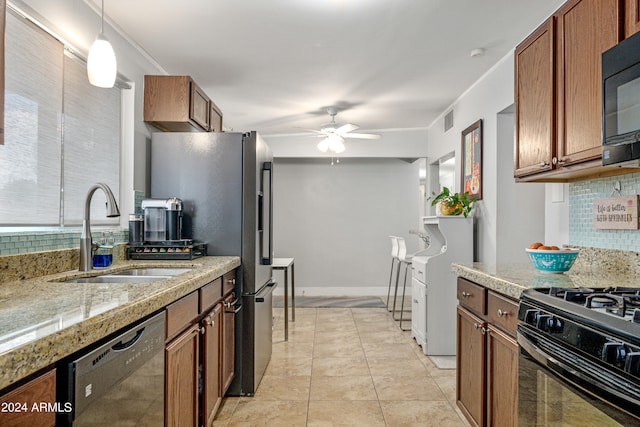 kitchen featuring hanging light fixtures, decorative backsplash, black appliances, ceiling fan, and sink